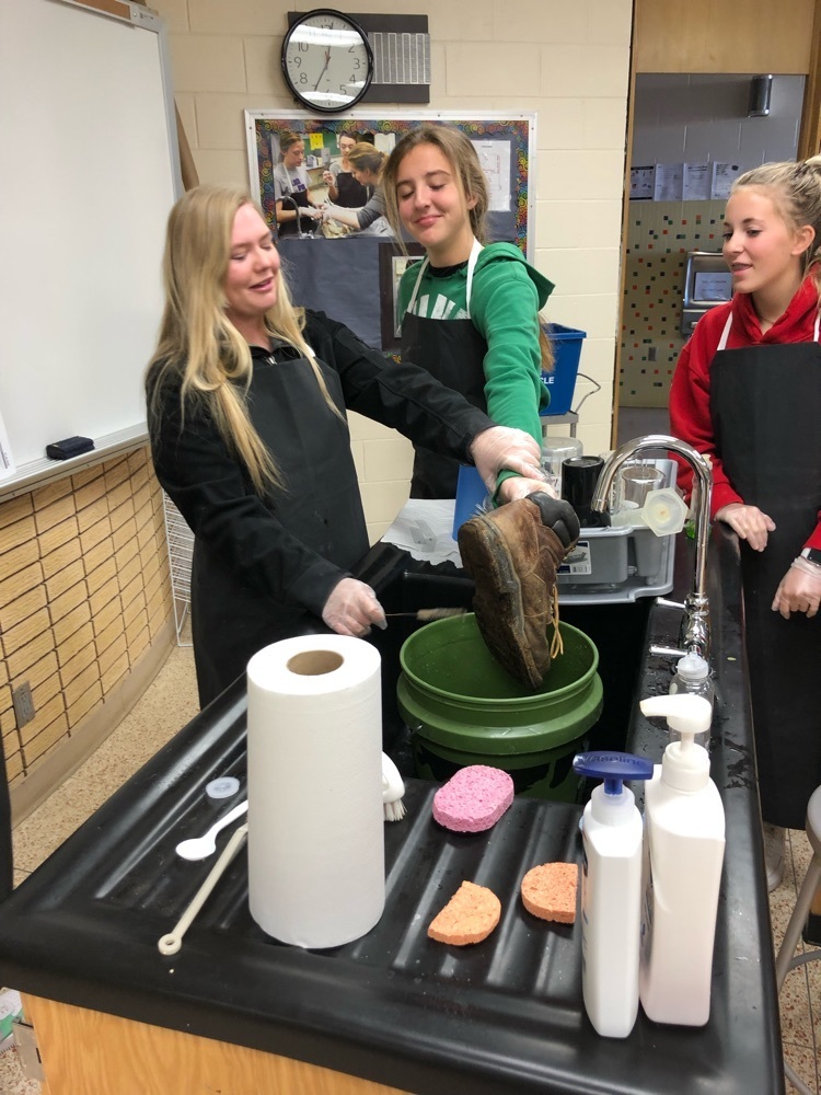 girls learning to clean boots